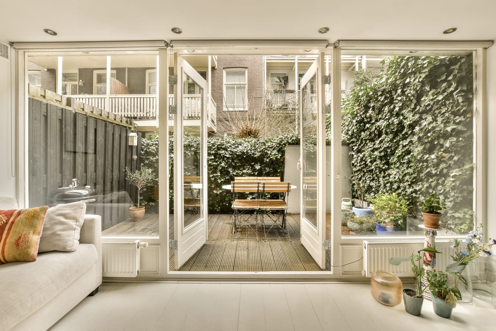 Open glass patio doors connecting a living room to the garden