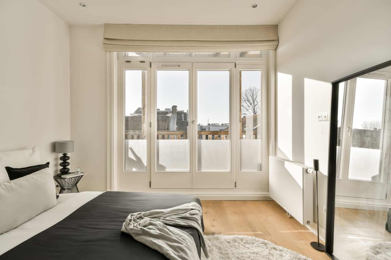 White French doors opening from a bright bedroom