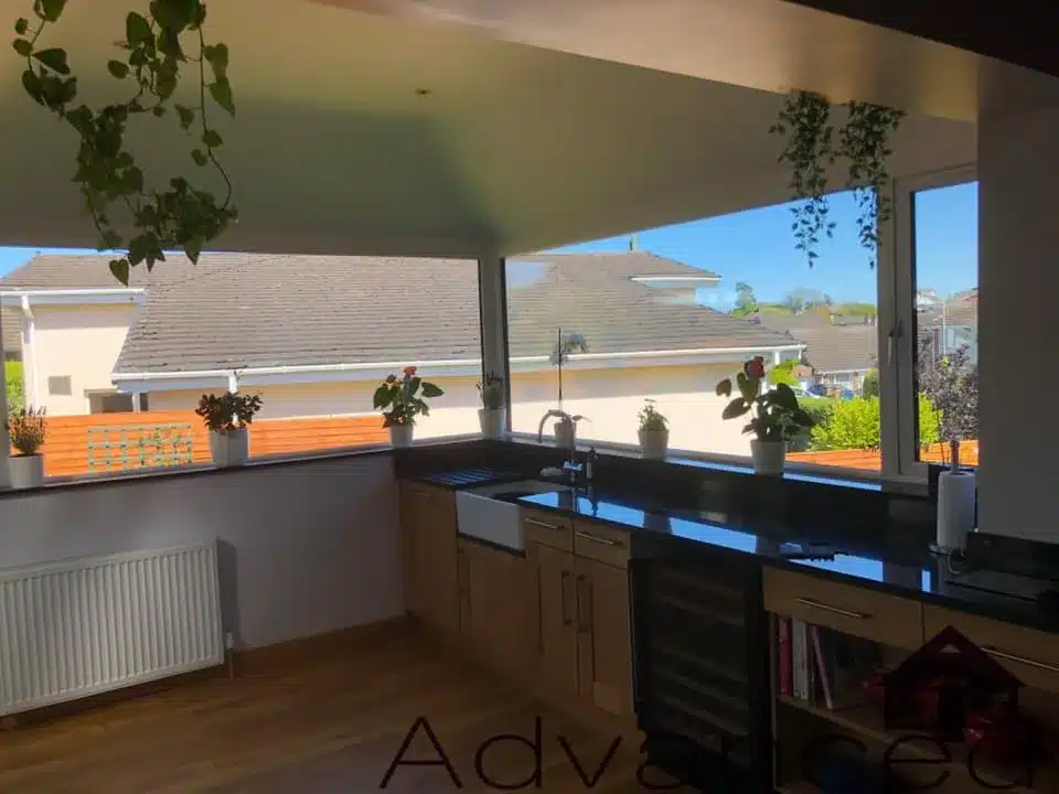 Open-plan kitchen with wide sunroom windows