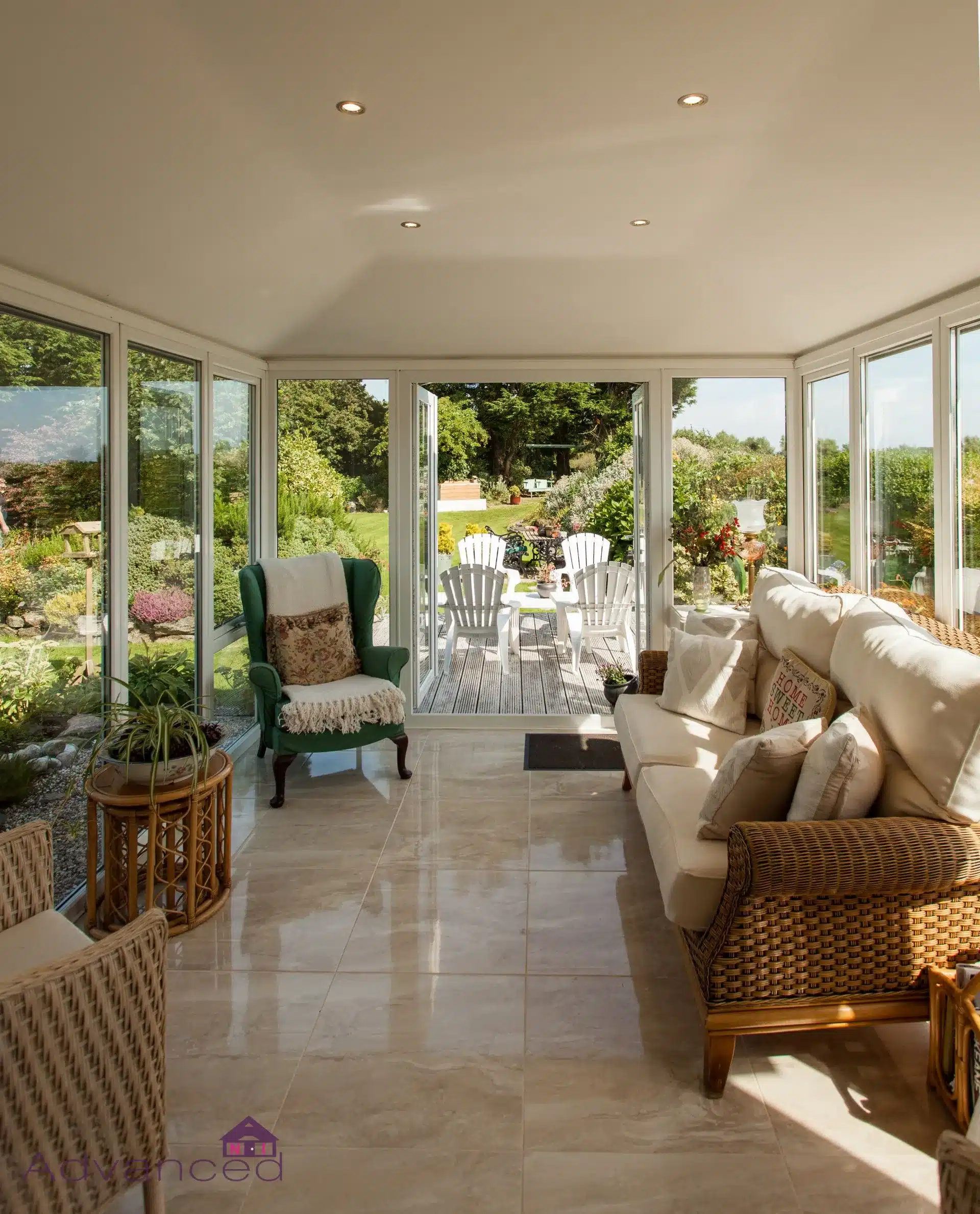 Bright conservatory living room with rattan furniture and garden view