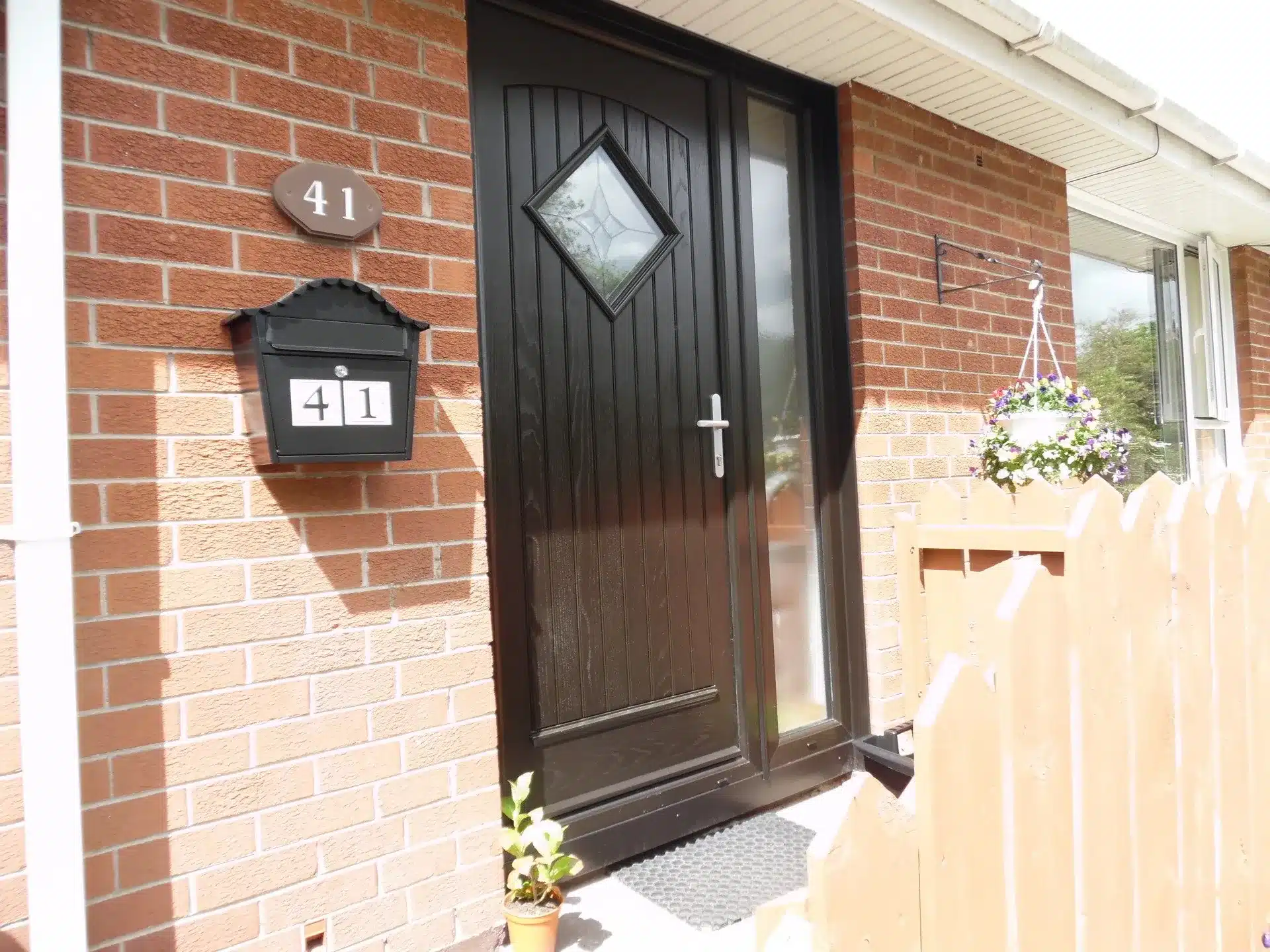 Dark brown composite front door with diamond-shaped glazing