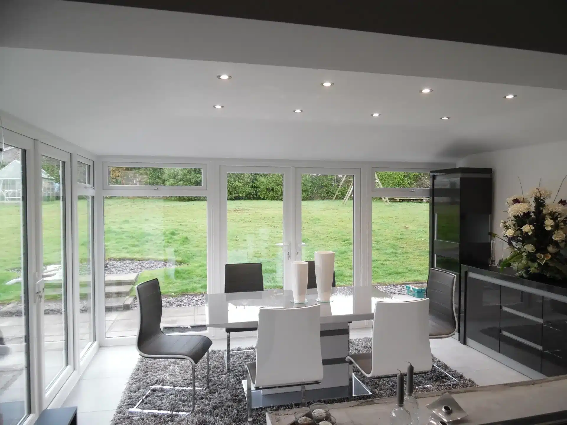 Bright sunroom dining area with full-height windows