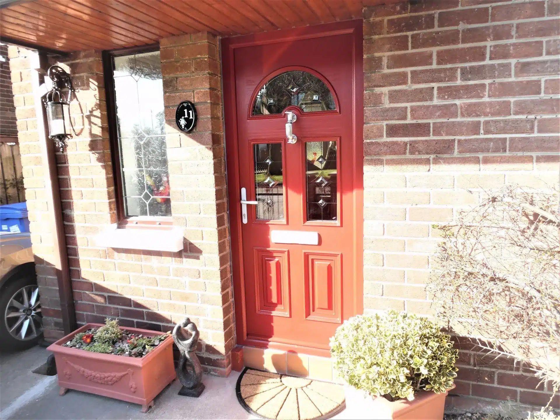 Red composite front door with arched decorative glass