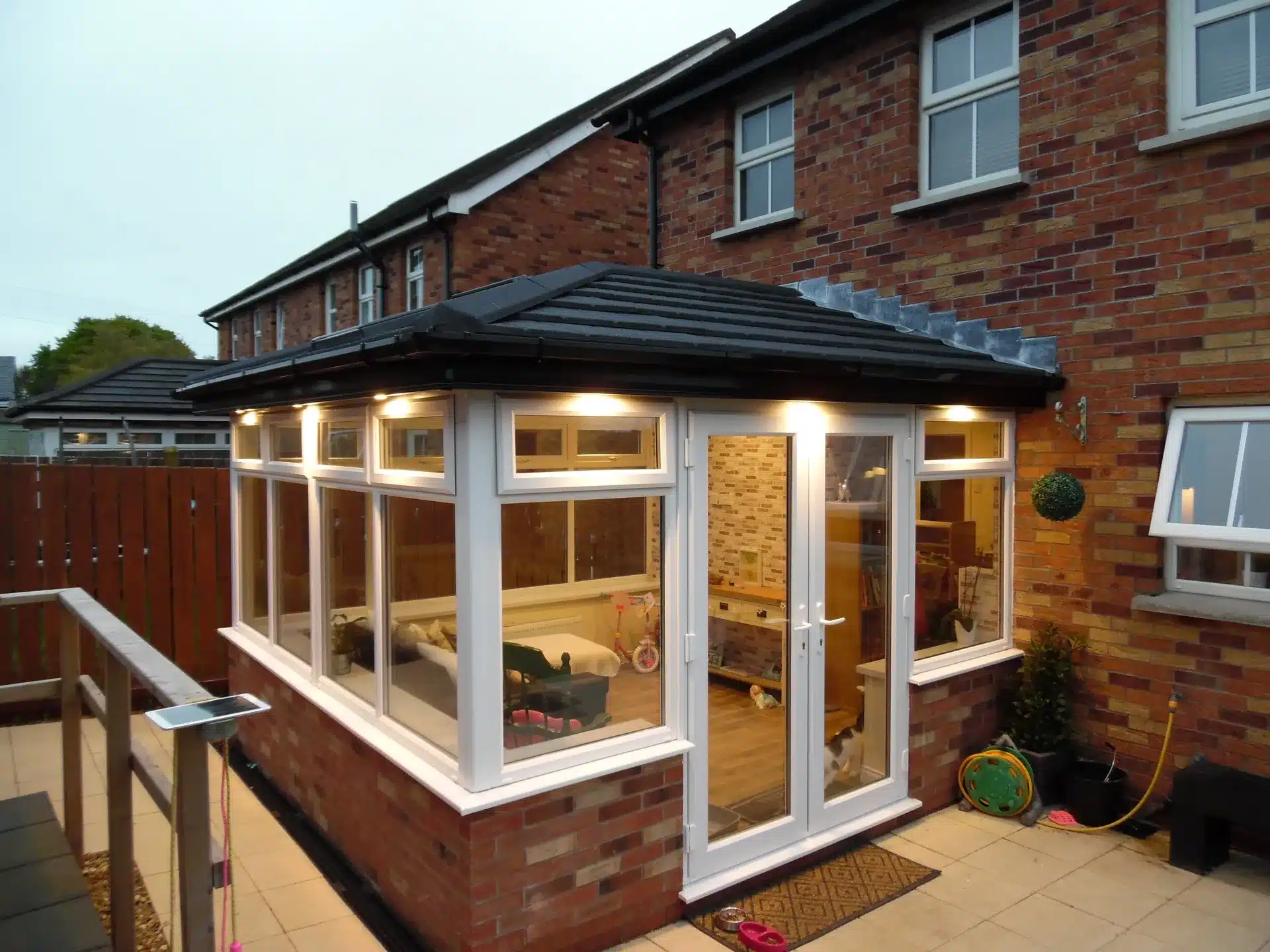 Sunroom project with white PVCu windows and patio doors, dusk exterior