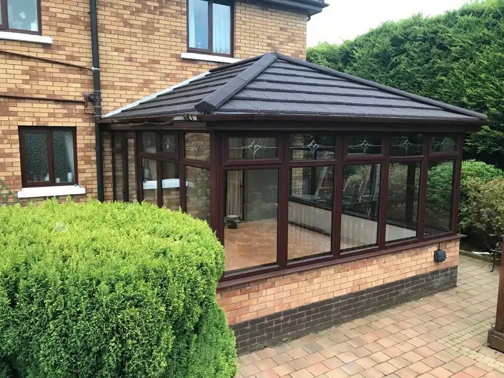 Conservatory with a dark tiled roof conversion in Belfast