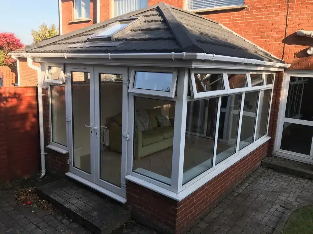 Conservatory roof conversion with grey tiles and roof light in Carnmoney