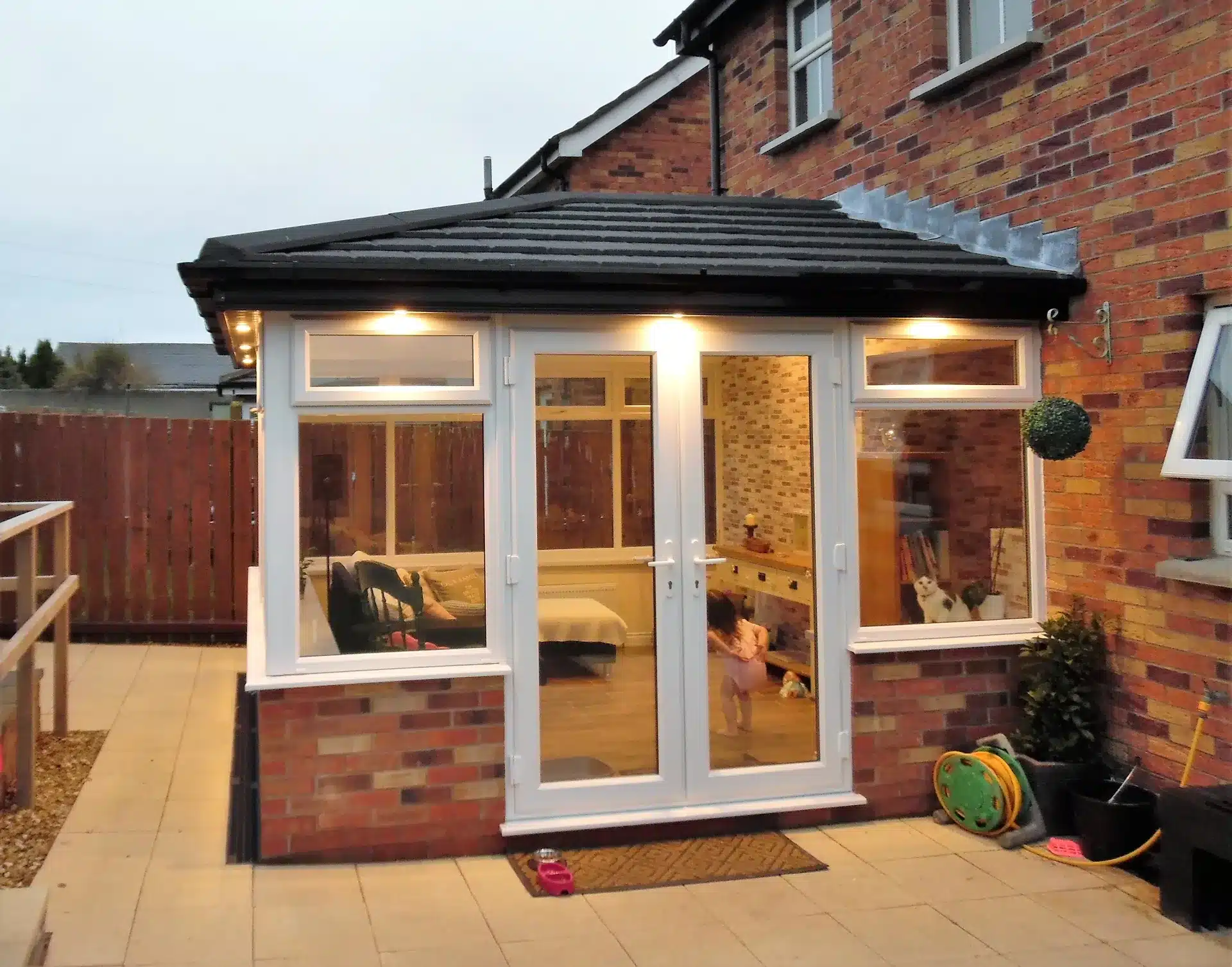 Sunroom extension illuminated at dusk