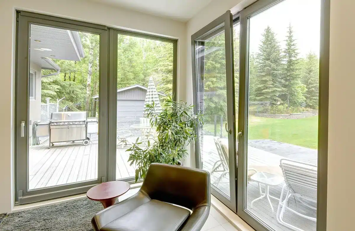 Grey tilt and turn window opening onto a garden