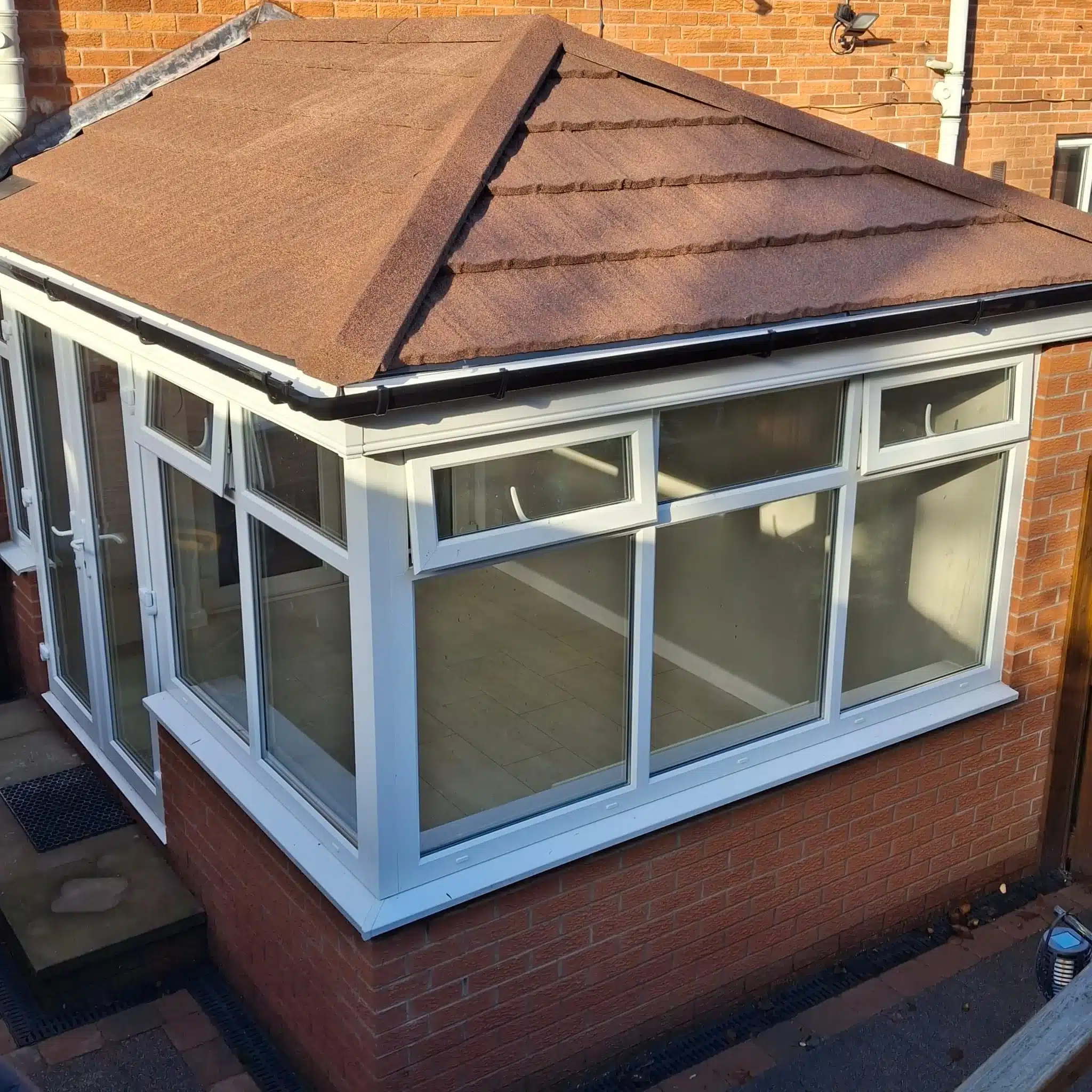 White conservatory extension with a tiled roof